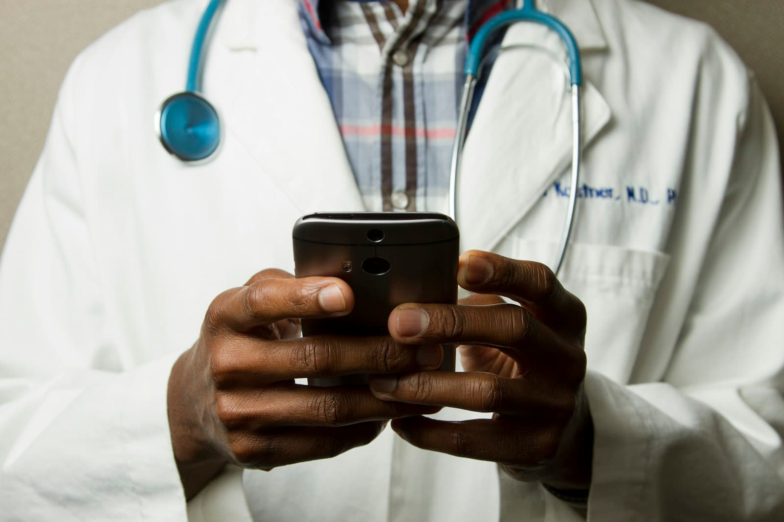 A doctor reviewing patient records on a tablet at a clinic desk